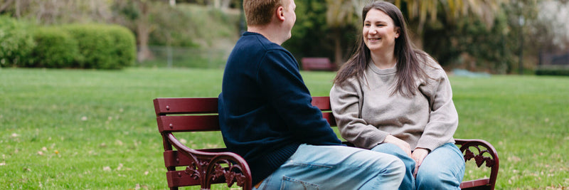Two people sitting on a bench in a park